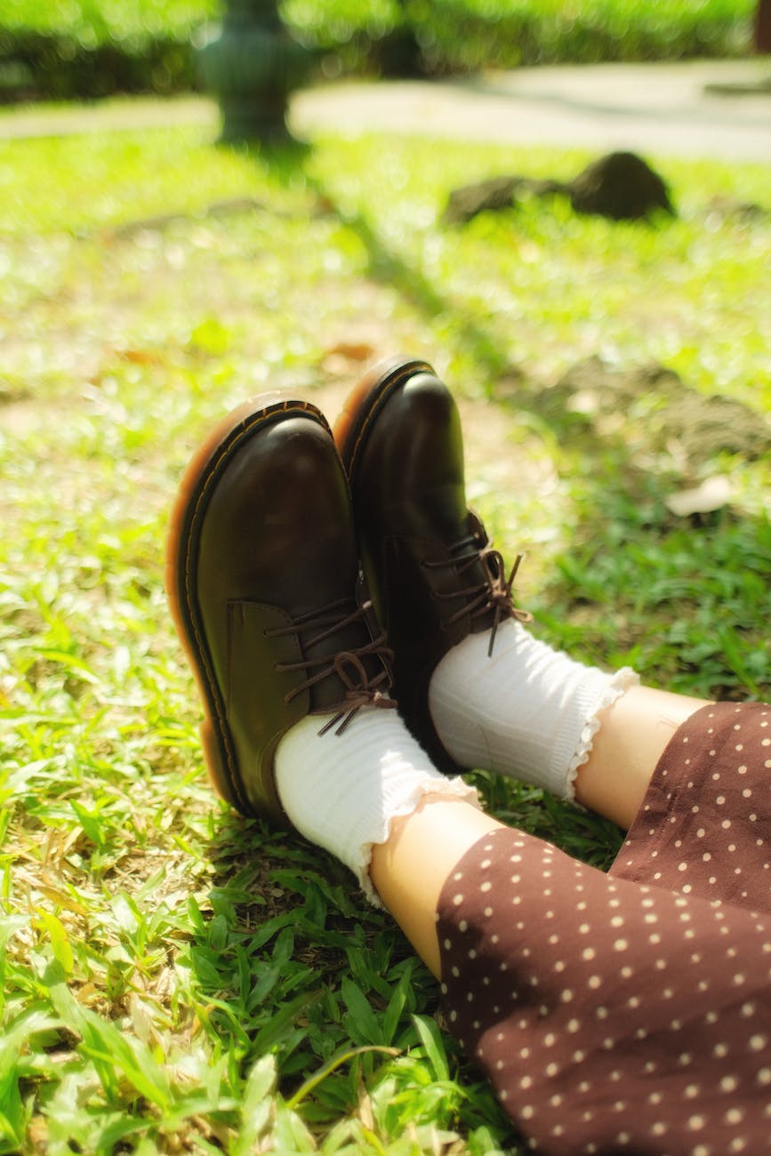 Retro loafers of a girl sitting on the grass sedentary lifestyle