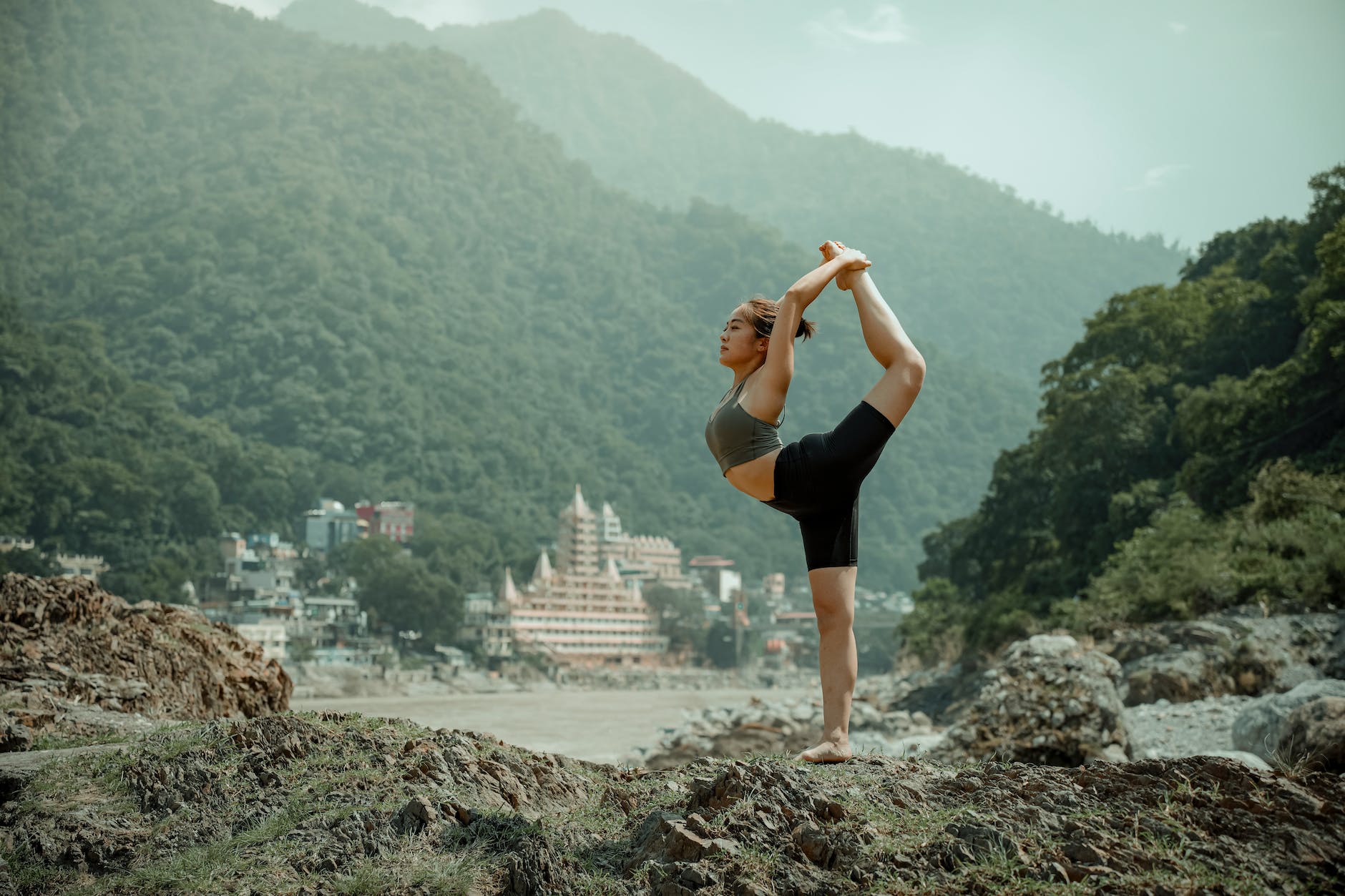Young woman standing on one leg on mountain in rishikesh india yoga sutras