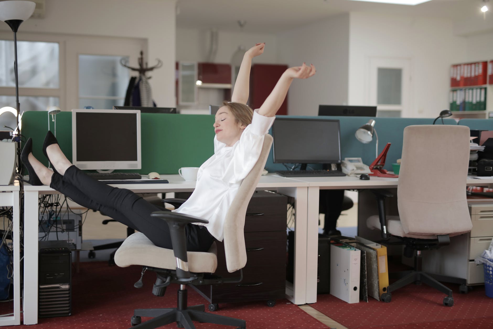 Female office worker relaxing with feet on table sedentary lifestyle
