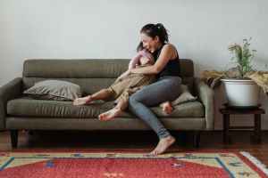 photo of woman sitting on couch while hugging her child connection between diet, fitness and mental health