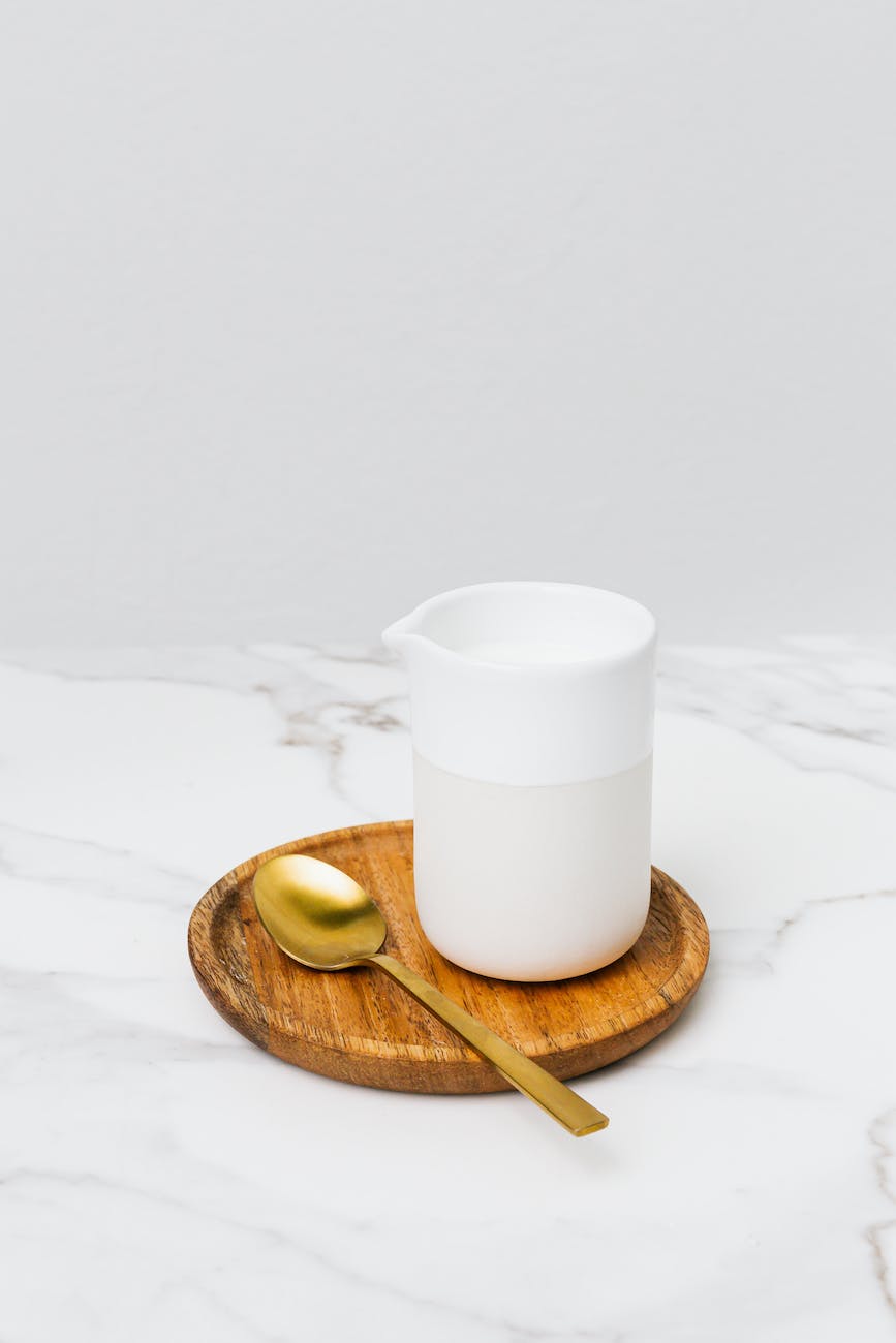 White ceramic milk server on the wooden saucer morning beverages