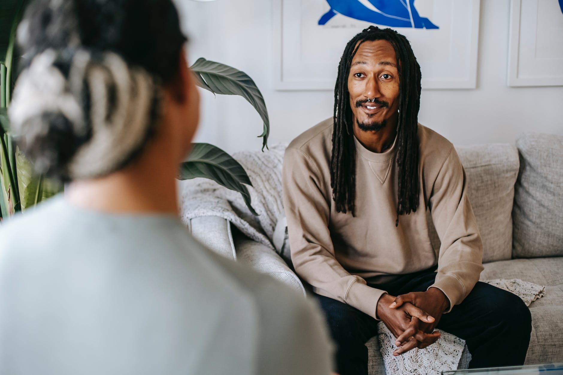 Black man talking to unrecognizable girlfriend in living room thriving relationship