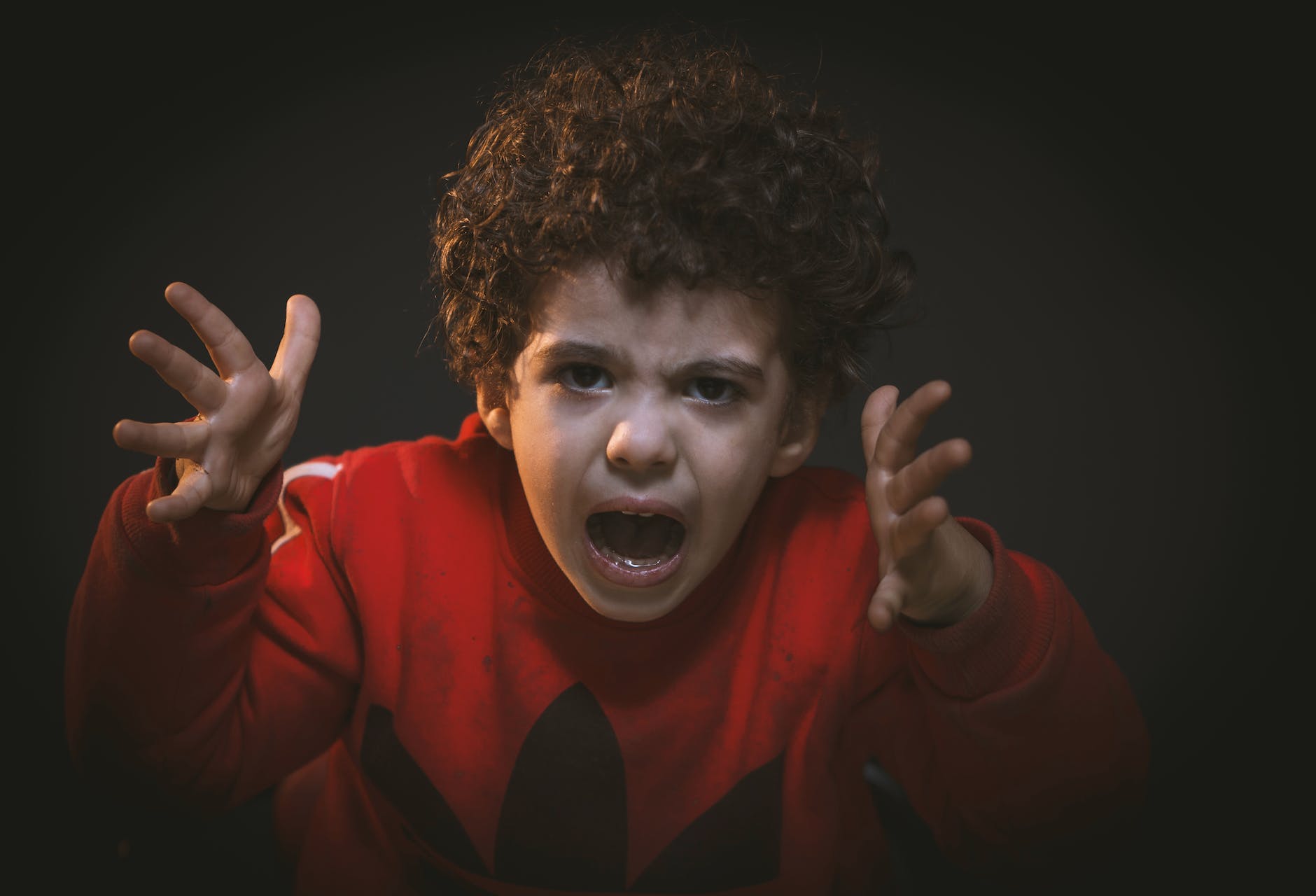 Toddler with red adidas sweat shirt anger
