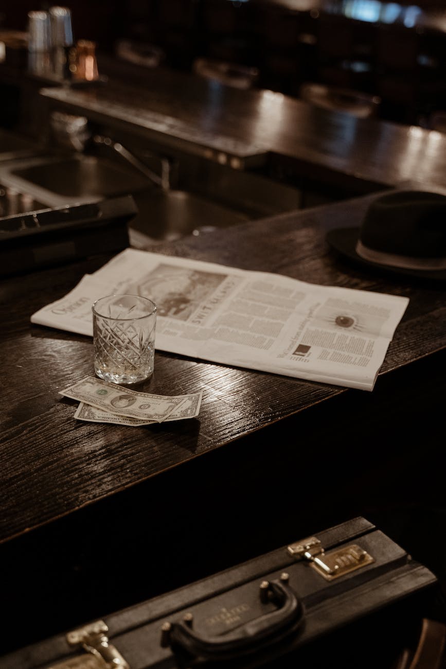 Black hat and newspaper on wooden counter financial education