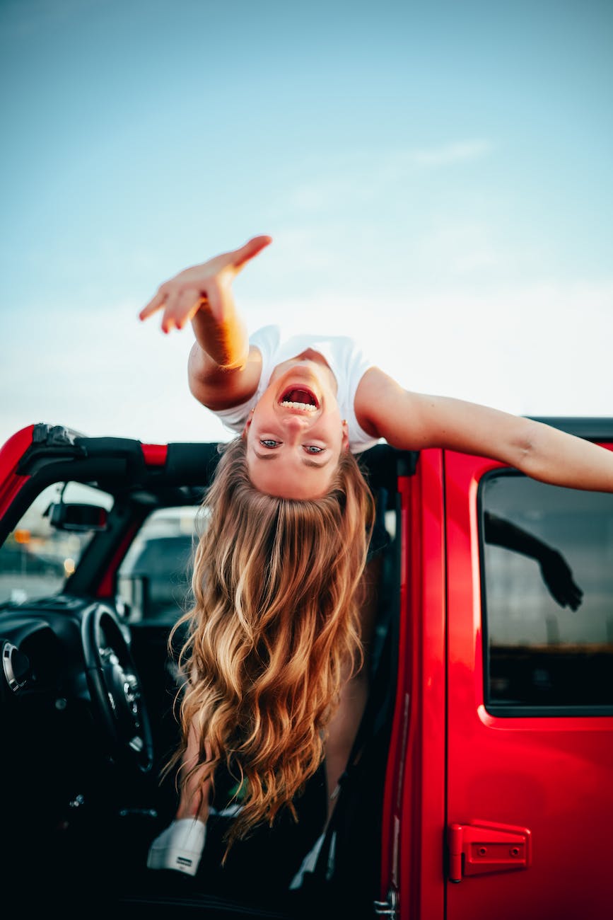 Girl laying on car roof reaching out smiling questions to ask your girlfriend
